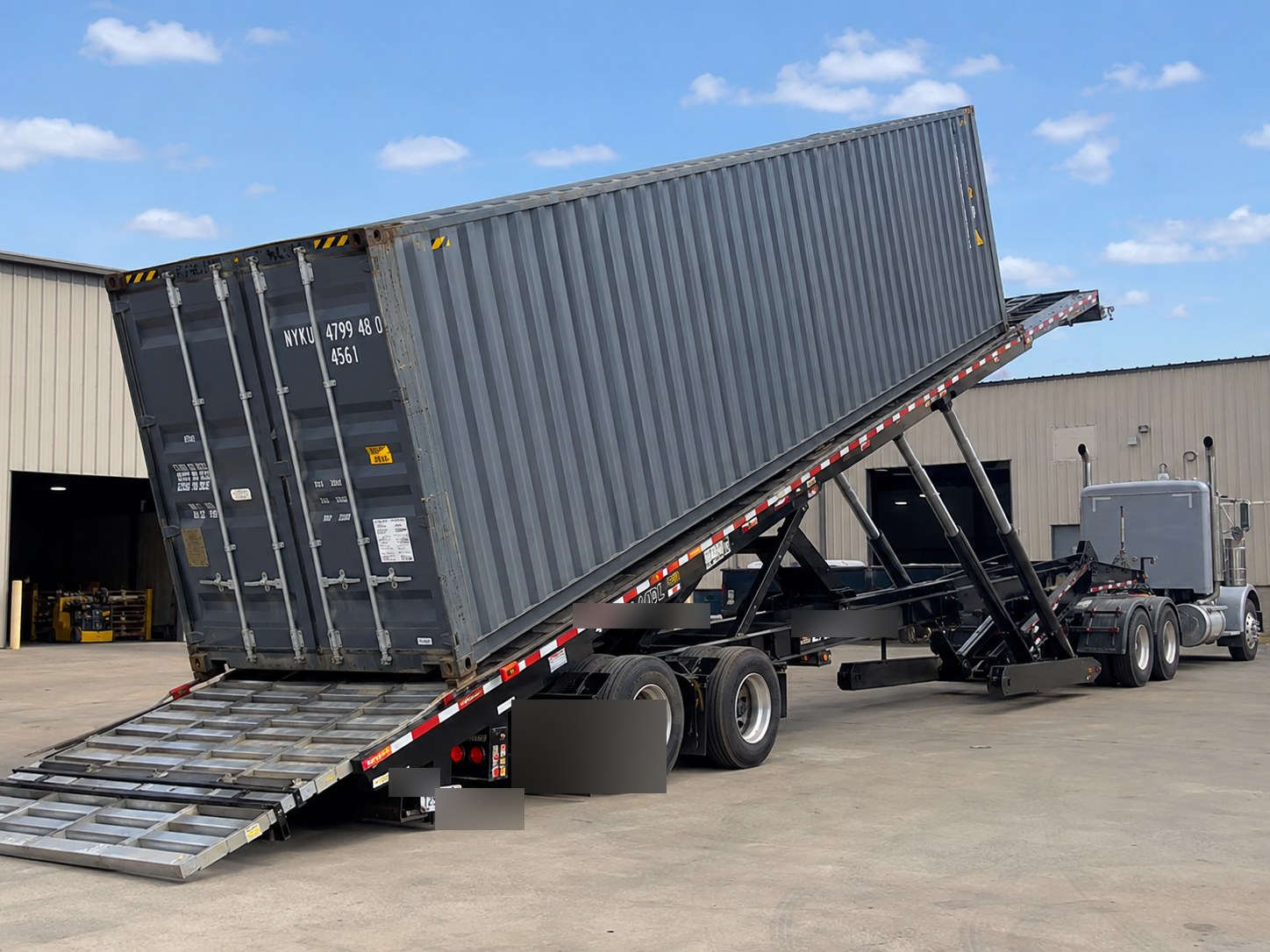 行走轴拖车（Traveling Axle / Tilt-Bed Trailer）将40尺集装箱倾斜卸到地面 — 无吊机/叉车的 OOG 重柜地面交付